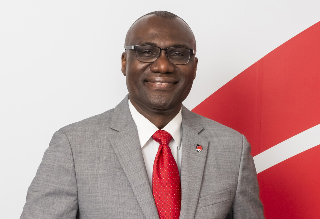 President Wisdom Tettey standing in front of the Carleton wave.