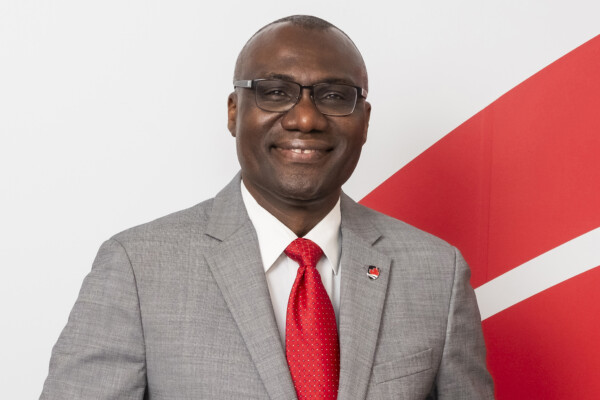 President Wisdom Tettey standing in front of the Carleton wave.