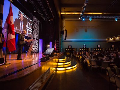 Carleton University President Benoit-Antoine Bacon addresses the crowd from a podium at a recent event.