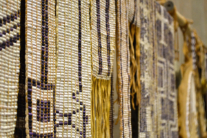 Several Wampum belts hanging from a display