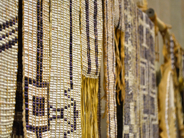 Several Wampum belts hanging from a display