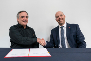 Carleton President Benoit-Antoine Bacon and Dominican University College President Maxime Allard sign a document renewing their affiliation agreement