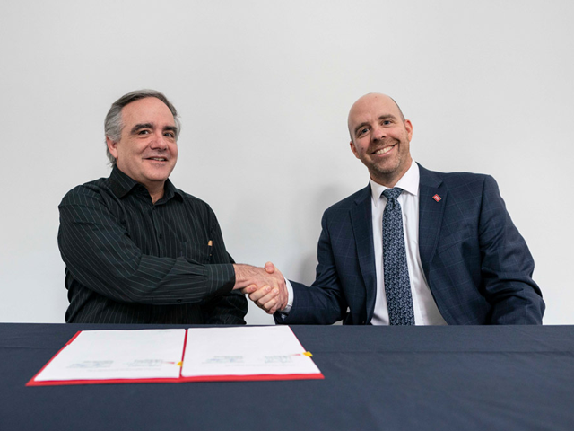 Carleton President Benoit-Antoine Bacon and Dominican University College President Maxime Allard sign a document renewing their affiliation agreement