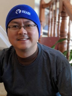 Adrian Chan, READi director smiles in his READi blue beanie