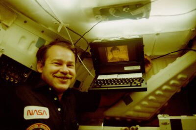 Astronaut John Creighton posing with a Grid Compass aboard Space Shuttle Discovery mission in 1985