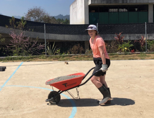 Student with a wheelbarrow while on Alternative Spring Break.