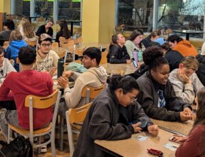 Students sitting at tables and playing Bingo.