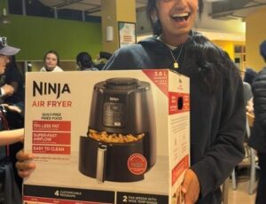 Student displaying their bingo prize: Ninja Air Fryer.