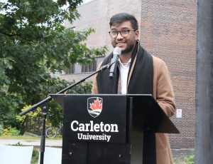 Mohamed Faris of CUSA addressing the crowd at a podium for the Pride Festival Opening Ceremony.