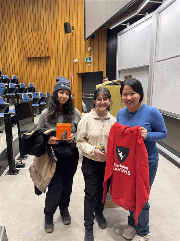 Three students with prizes.