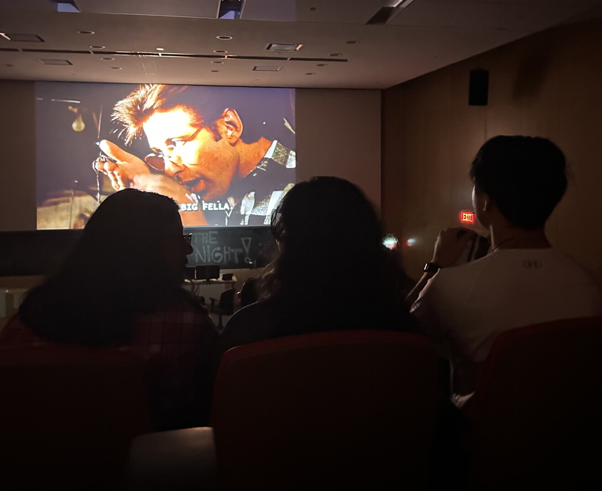 Students watching a movie on the big screen.
