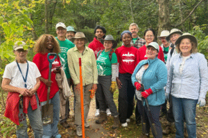Students posing for group photo outdoors while helping out with a Campus to Community event.