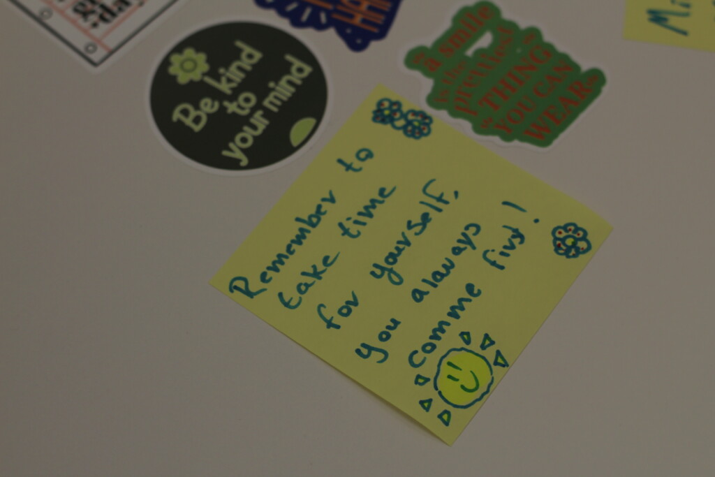 Yellow sticky note with writing on it that reads "Remember to take time for yourself, you always comme first!"