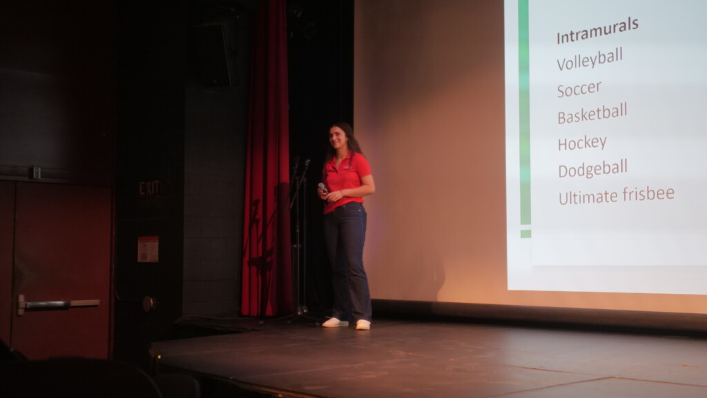 student presenting in front of screen.