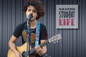 Student Playing Guitar with a microphone.