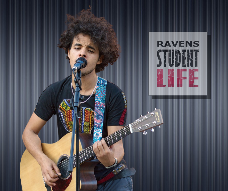 Student Playing Guitar with a microphone.