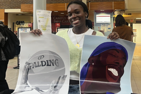 Artist holding up paintings they have created