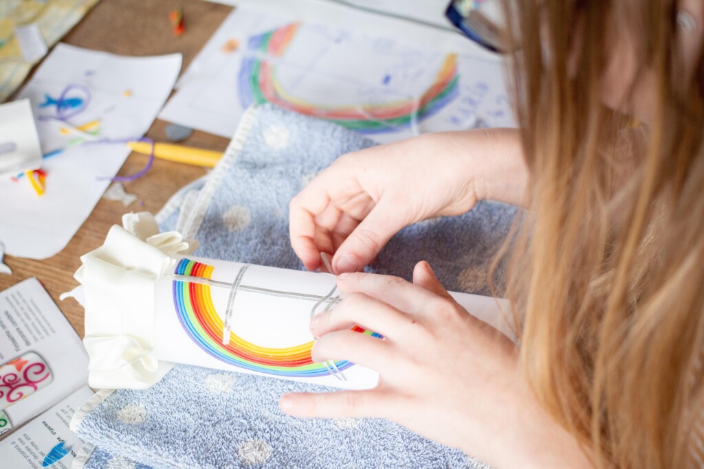 close up photo of students hands while working with needle-point crafts.