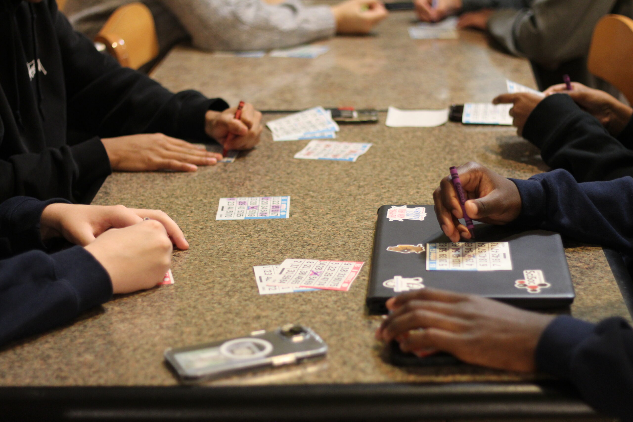 Close up of students bingo cards as they are being filled out during the game.