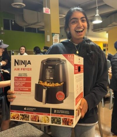 Student displaying their bingo prize: Ninja Air Fryer.