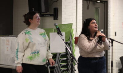 Two students with microcu_people_phones singing karaoke.