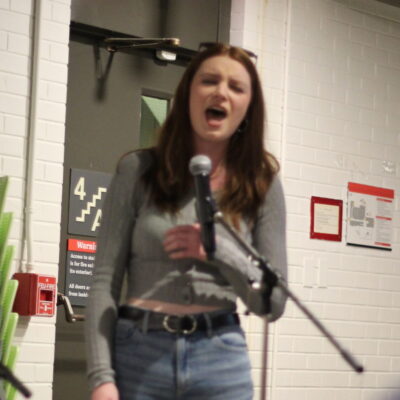 A student singing into a microcu_people_phone for karaoke.