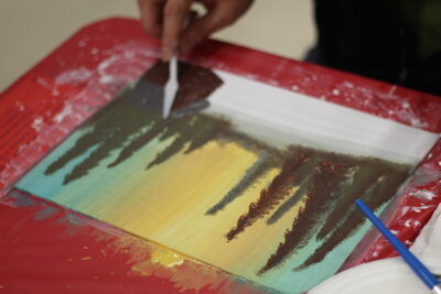 A close up of a paint canvas that is being worked on by a student.