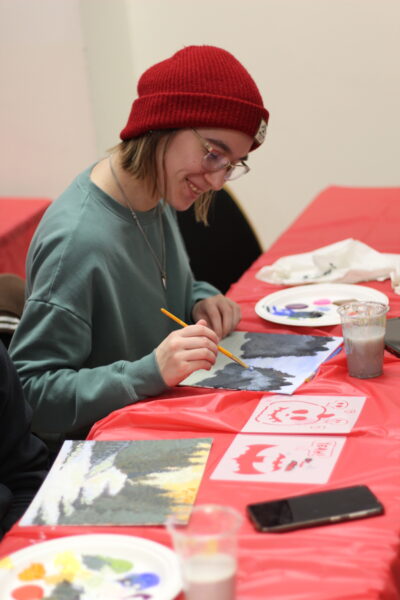 One student painting their canvas.