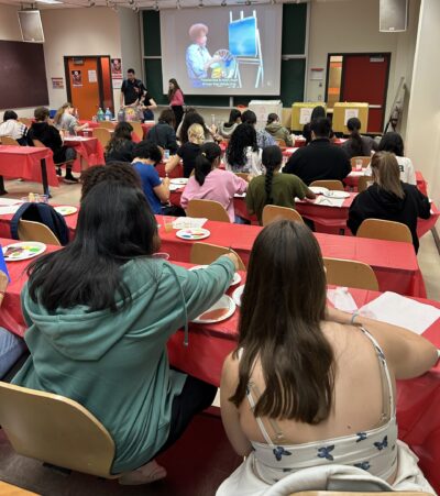Students painting with Bob Ross Video in background.