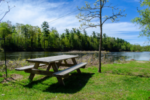 A picnic bench on the grass by a large river