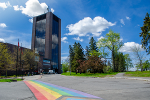 A pride crosswalk with Dunton Tower in the background