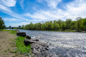 A large river with dramatic clouds above