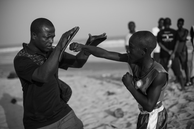 Twelve-year-old Michael Dicadi Nelson trains with his coach on the Jamestown beach in Accra, Ghana.