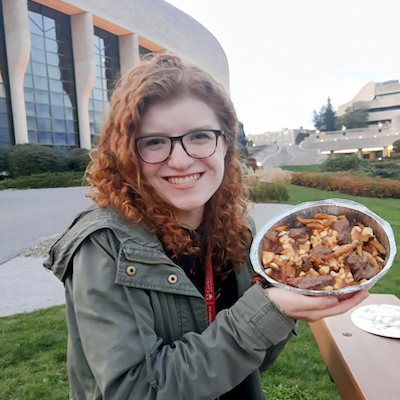 Erin holding a foil container of poutine