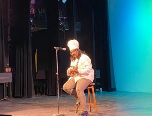 Lucksiha playing a ukulele in a chef's hat