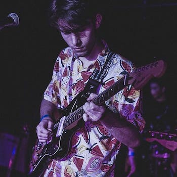 Tomas playing guitar in a Hawaiian shirt