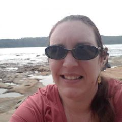 Rebekah at the beach in Australia. Ocean behind her. The tide appears to be out.