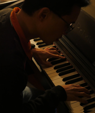Kevin with his hands on the keyboard of a piano
