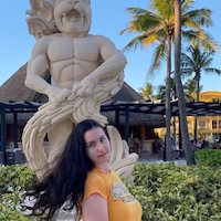 Anna in front of a statue on a tropical island