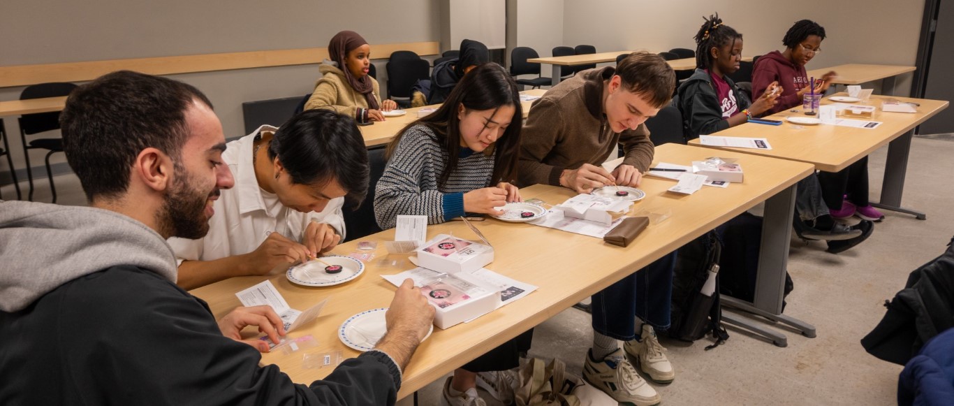 students gathered around the table engrossed in the creation of abalone popsockets