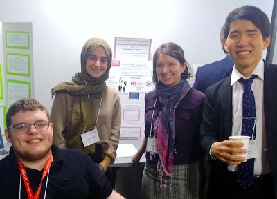 Four students in front of their poster