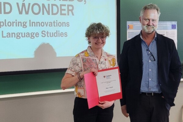 Mar Pauls holds the Lynne Young Award, stands beside Interim School Director Geoff Pinchbeck