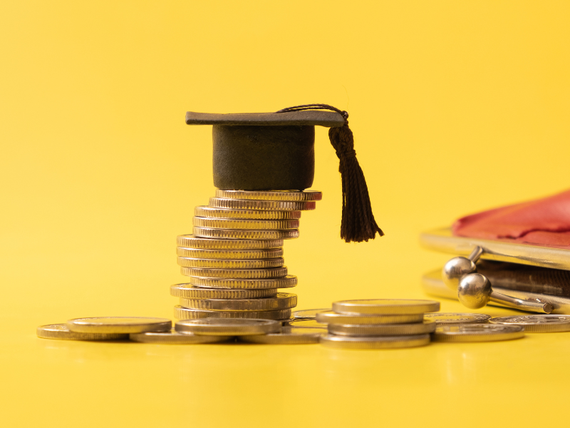 Image of stack of coins with graduation cap on top