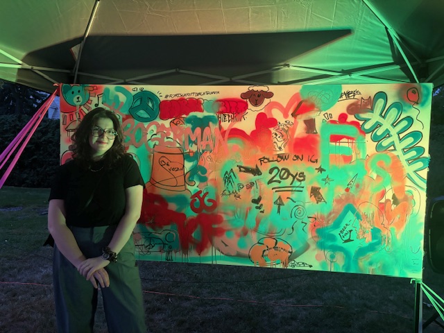 An image of a student in front of graffiti art