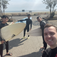 Scott with his surfboard and friends at the beach.