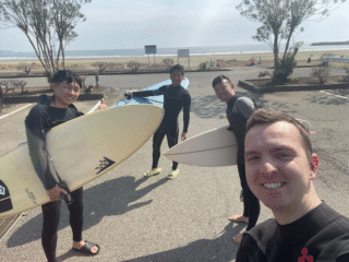 Scott with his surfboard and friends at the beach.