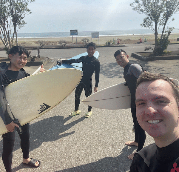 Scott with his surfboard and friends at the beach.