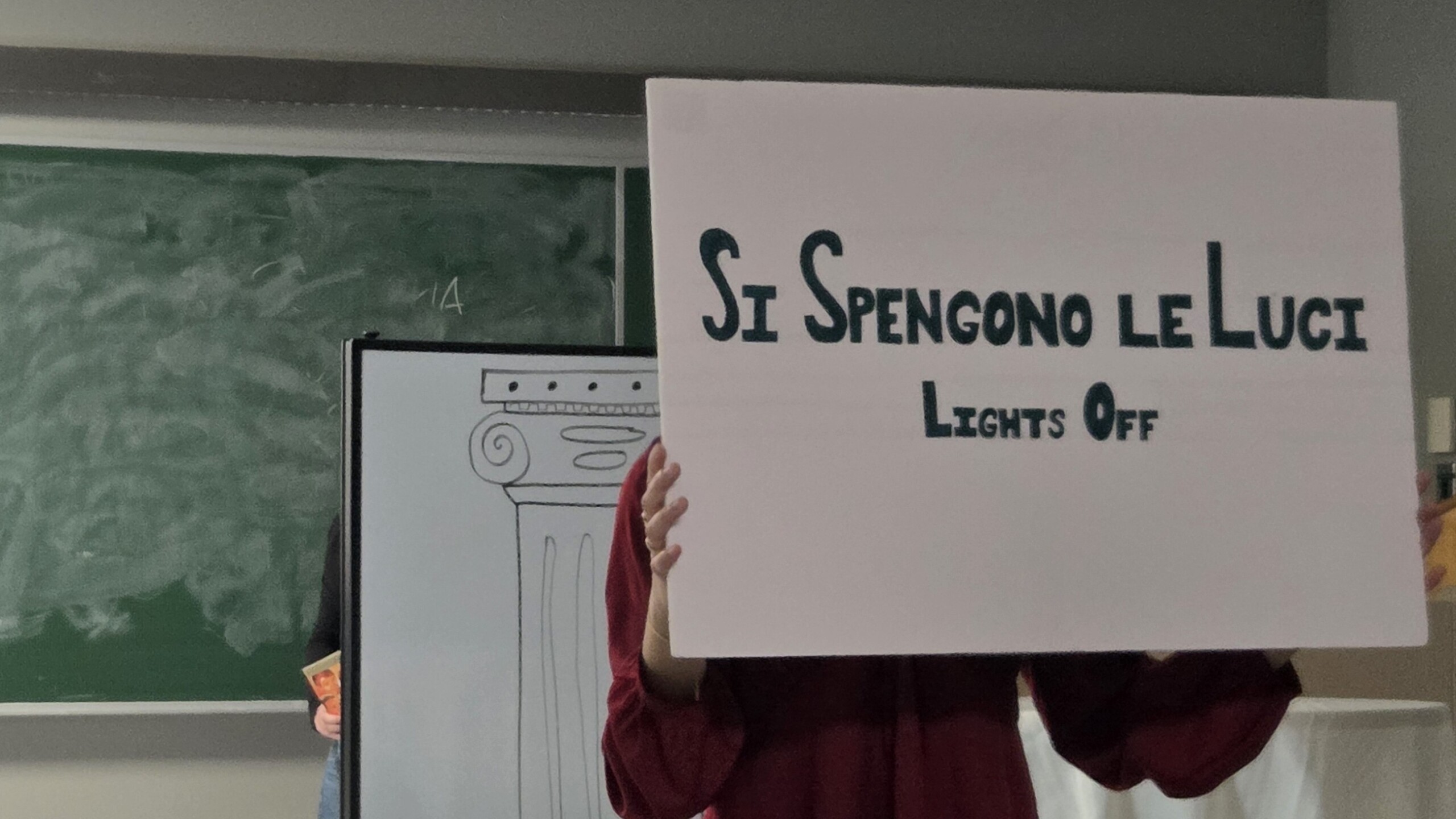 Student holds sign that reads "Lights off"