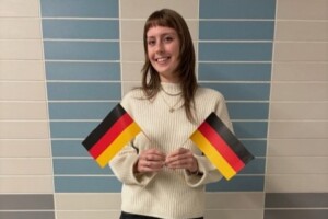 Image of a student, Maggie, holding two German flags
