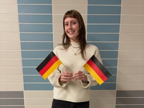 Image of a student, Maggie, holding two German flags